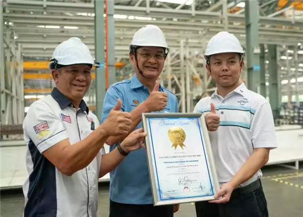 工程部部长巴鲁比安（左一）亲自为森林城市颁发“全马最大全自动化建筑工业化基地”证书